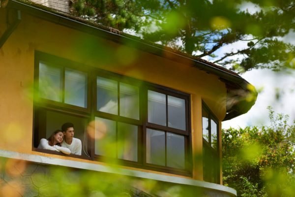 long shot of couple looking out the window of their new house